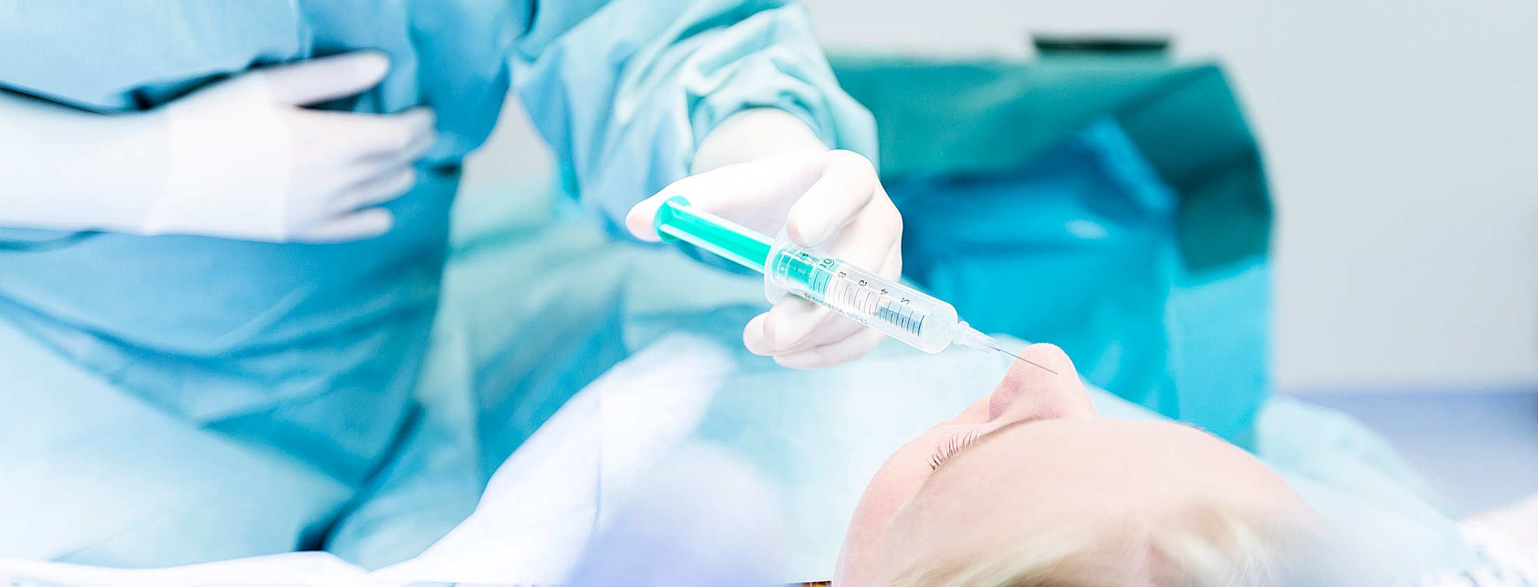 Patientin bei einer individuellen Schönheitsbehandlung gegen den natürlichen Alterungsprozess. Fachärztin führt eine Botox-Spritze an eine Falte im Gesicht der Patientin. Dank kompetenter Beratung liegt die Patientin entspannt und ist zuversichtlich.