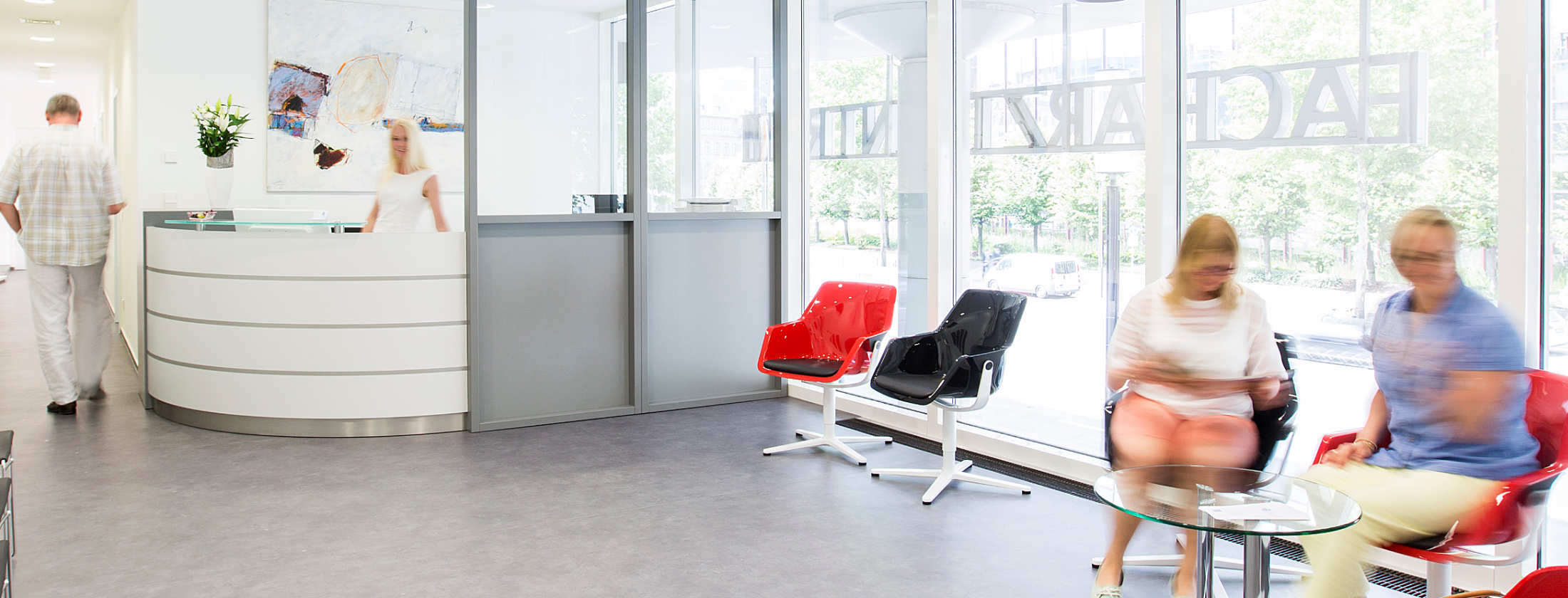 Приемная частной клиники Бергер в Вест-энд, Франкфурт. Можно присесть на дизайнерские стулья и подождать пока медицинский работник за округлённой регистрацией подойдёт к вам для консультации о пластической хирургии. Гигантские окна наполняют зал светом.